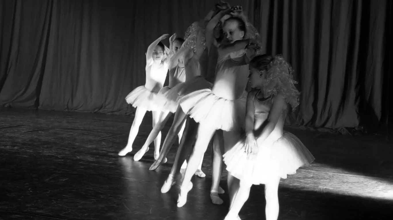 Balletdansere i hvide tutuer under en opvisning på scenen